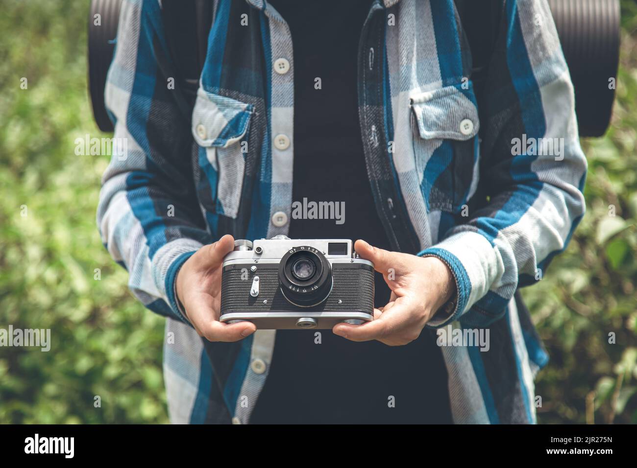 Appareil photo de film vintage dans les mains de hommes sur une randonnée dans la nature. Banque D'Images