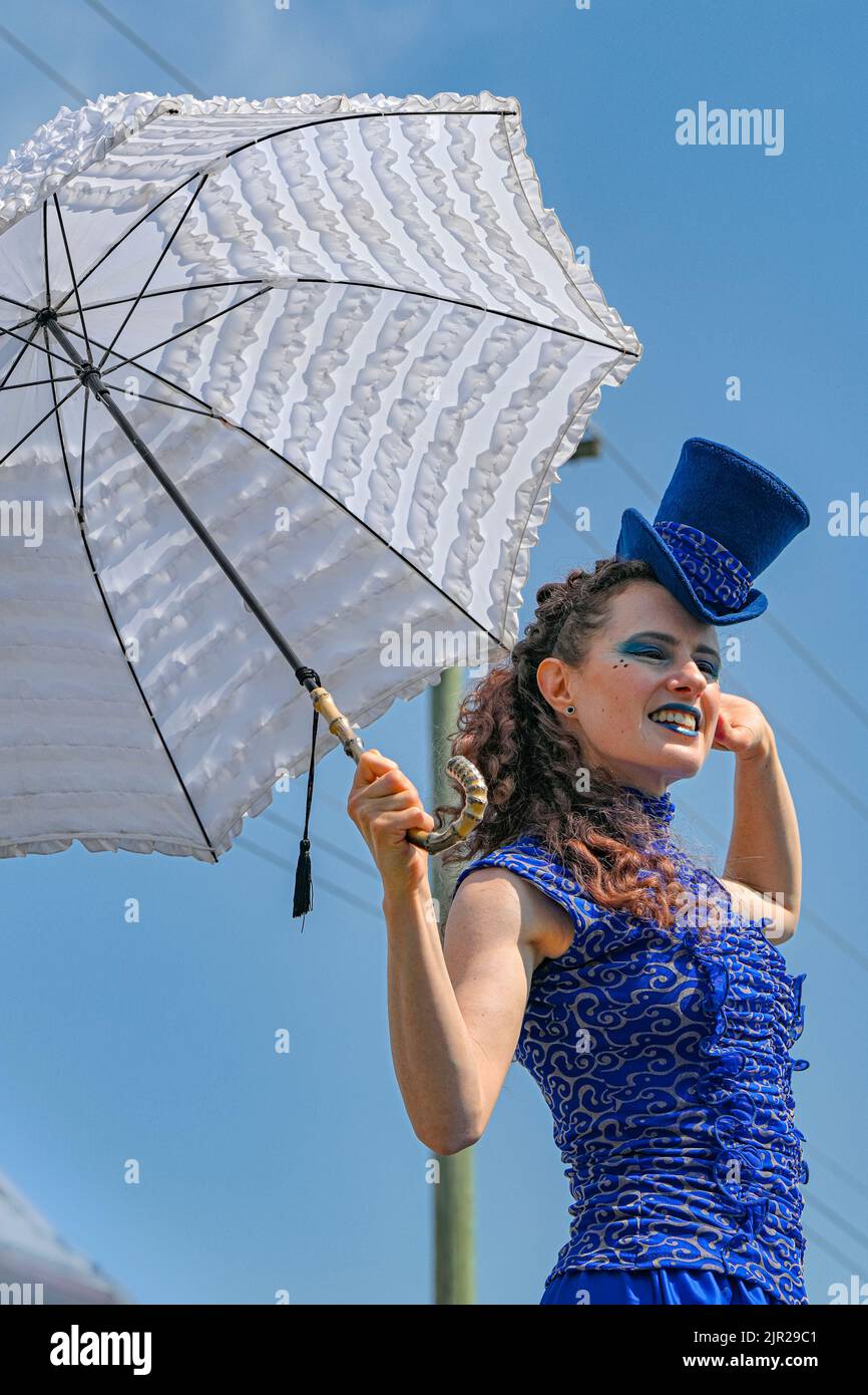 Marcheur à pilotis avec parasol, Alive Festival, centre-ville de Langley, Colombie-Britannique, Canada Banque D'Images