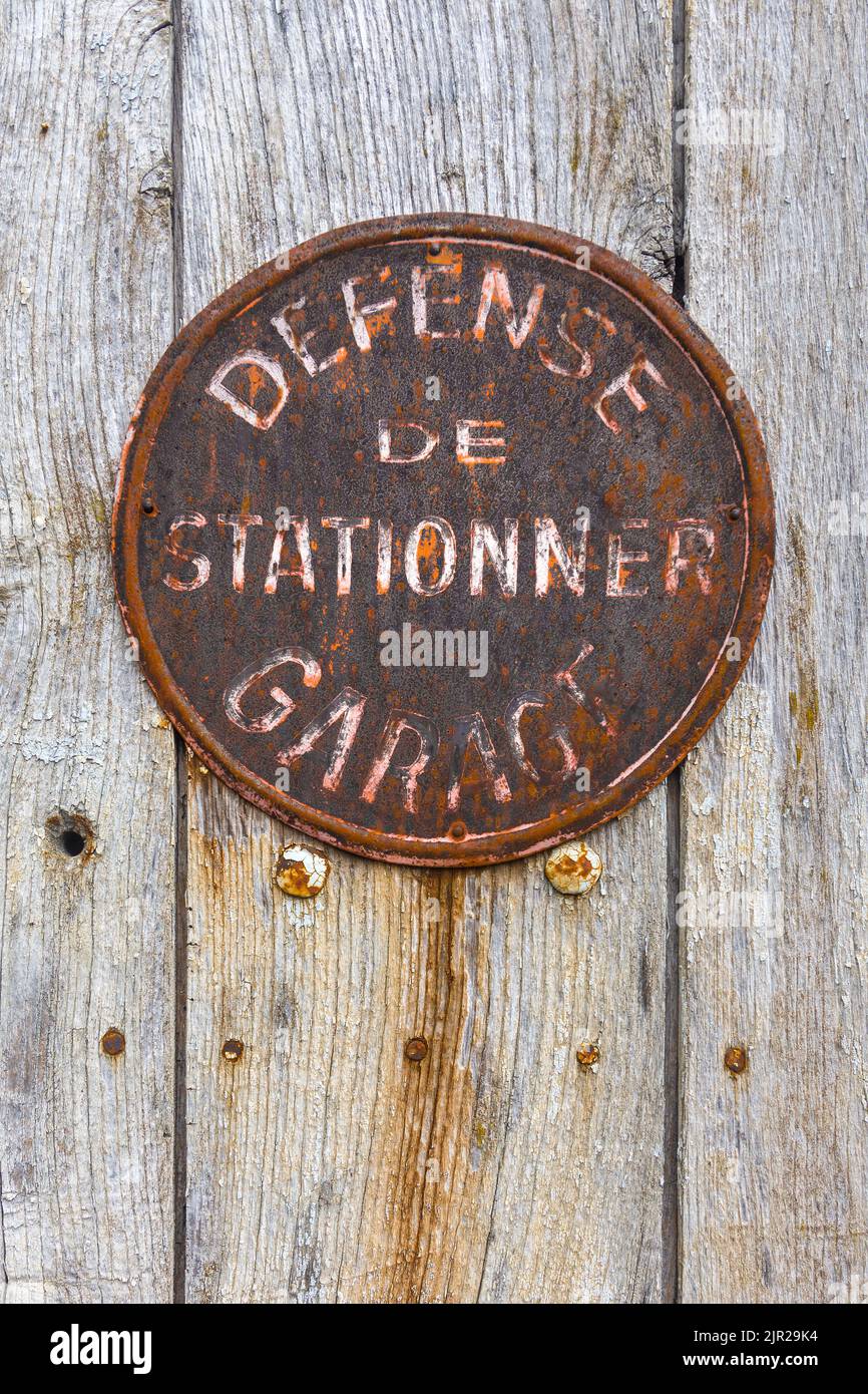 Vieux rouillé français pas de panneau de parking sur la porte de garage - Compreignac, haute-Vienne (87), France. Banque D'Images