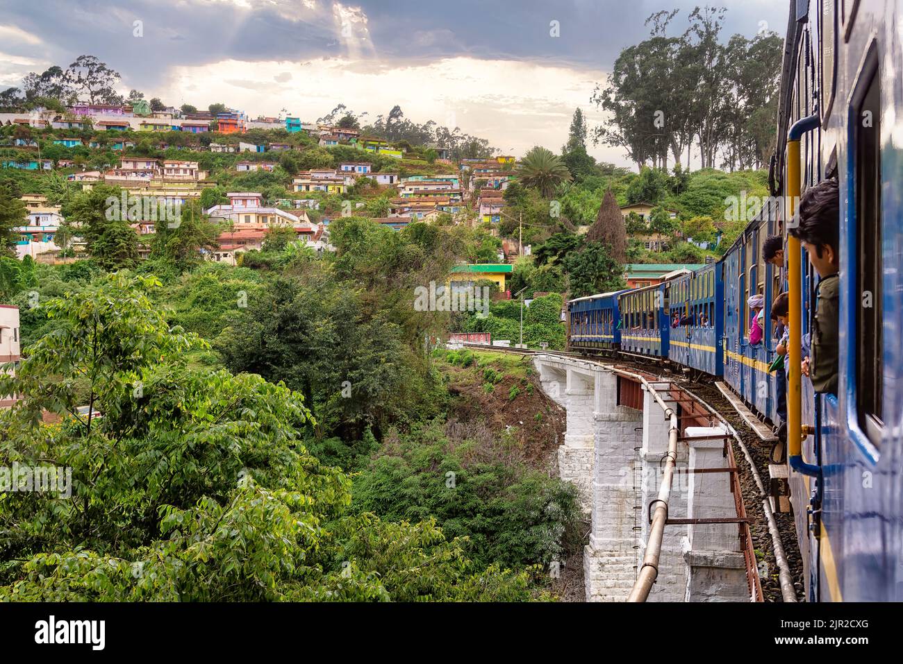 Wellington, Inde - 24 août 2018 : vue sur les montagnes et le village coloré de Tamil Nadu depuis l'intérieur d'un wagon du train de la montagne Nilgiri Banque D'Images
