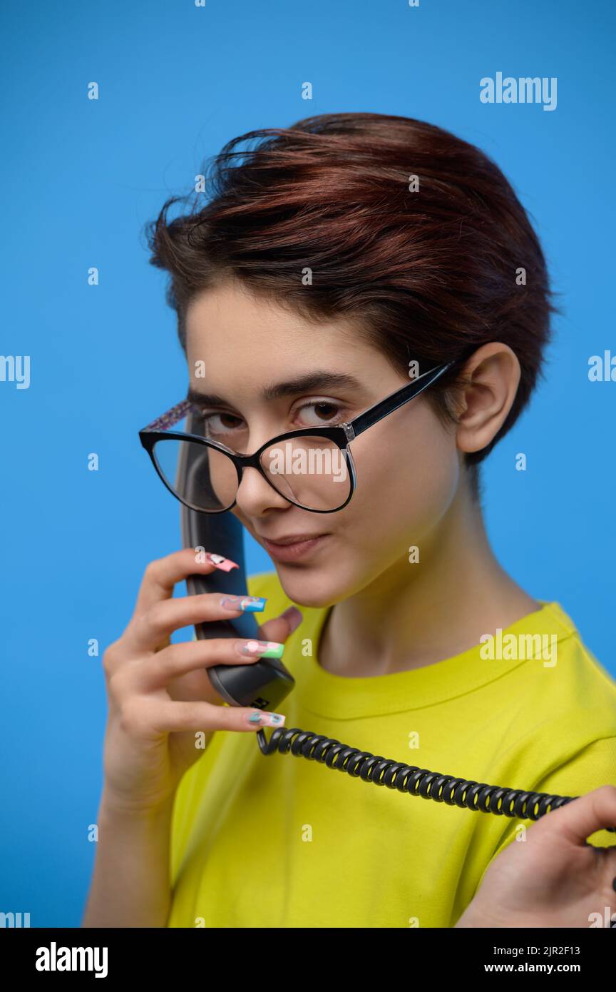 Jeune fille de brunette ayant une conversation téléphonique Banque D'Images