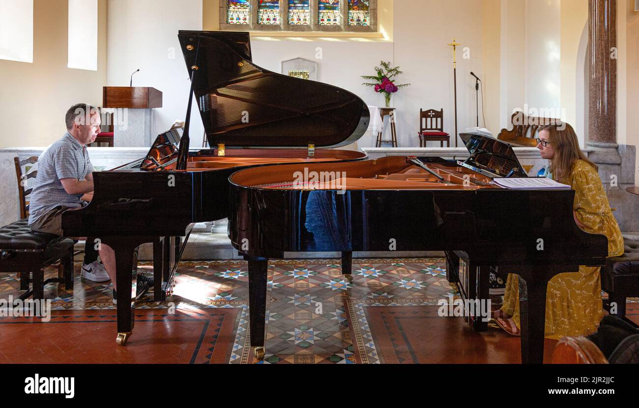 Deux pianistes jouant de grands pianos dans une église Banque D'Images