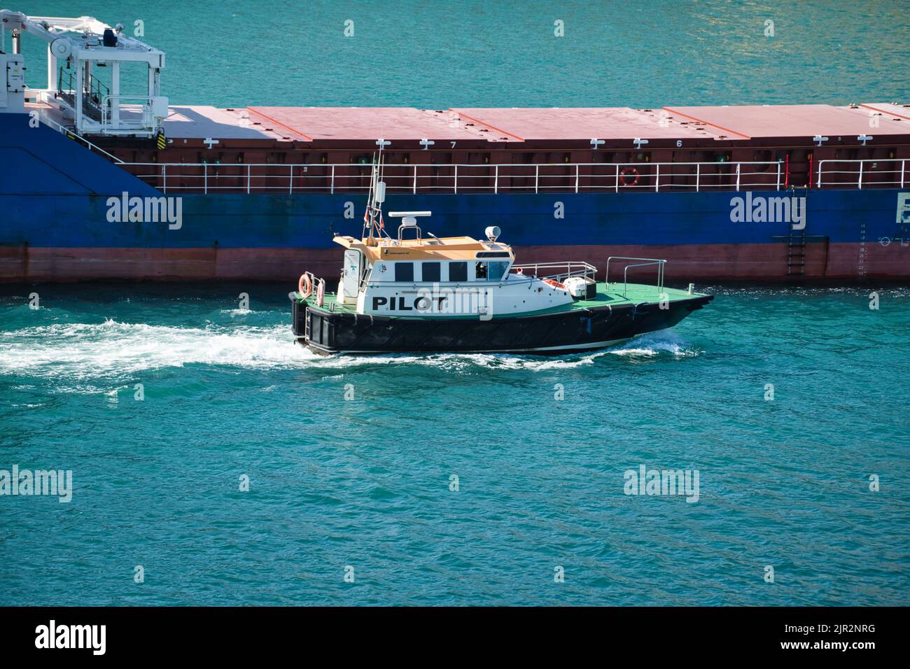 Vue d'un navire marchand quittant le port suivi du pilote Banque D'Images