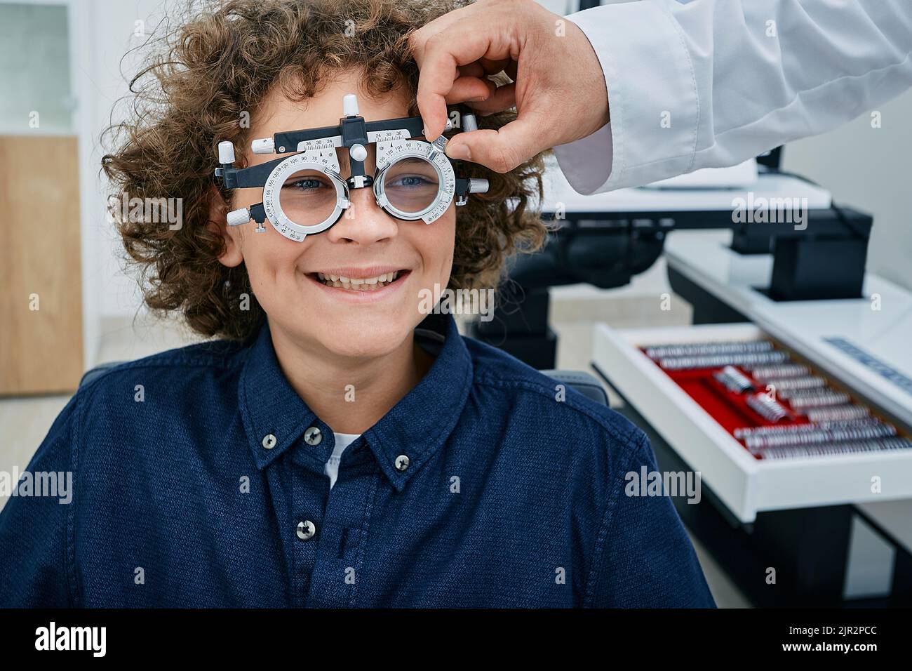 Optométriste sélection de verres de lunettes pour garçon mignon en utilisant le cadre d'essai optométriste et les lentilles à la clinique d'ophtalmologie. Test de vision pour enfants Banque D'Images