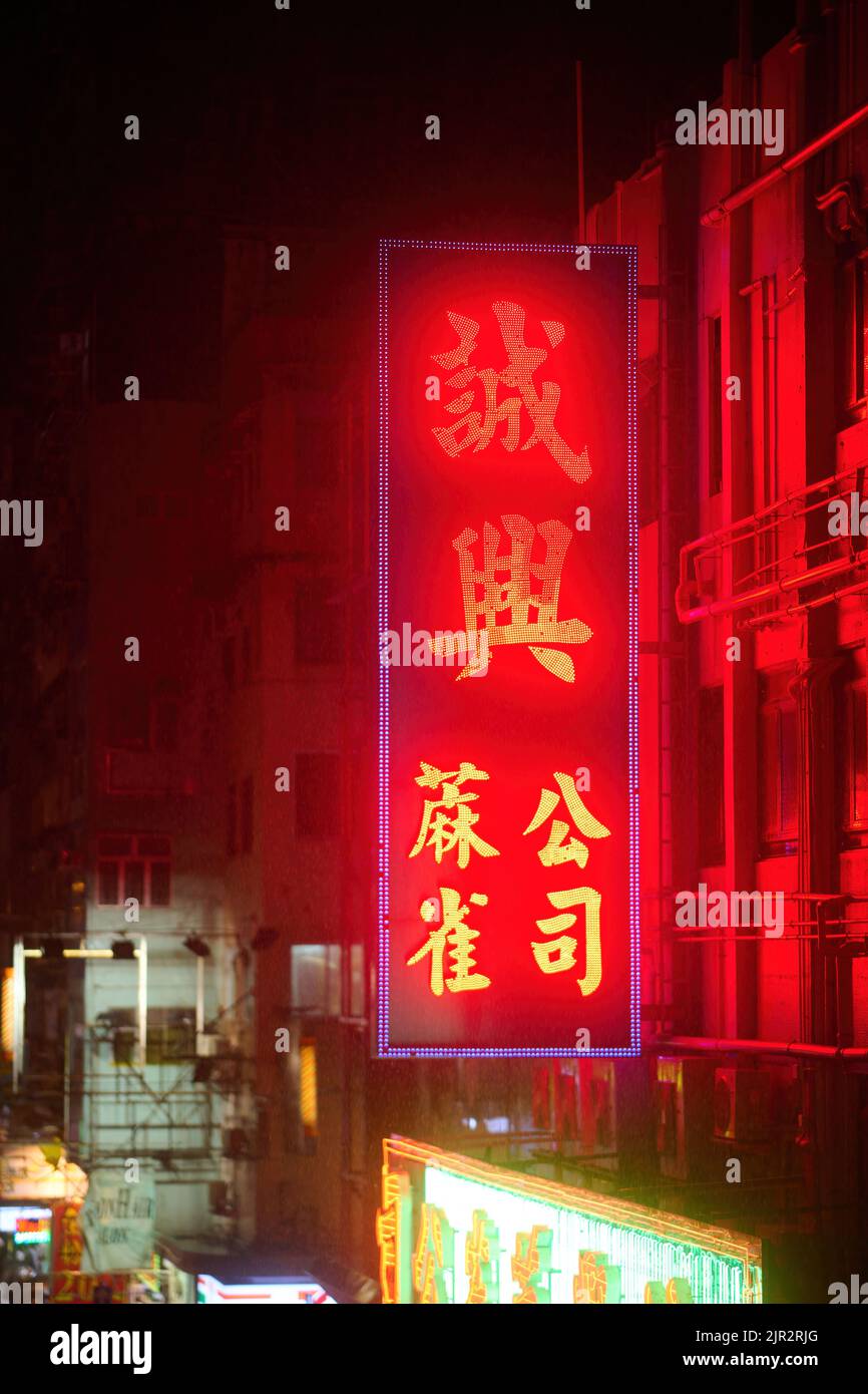 Un panneau au néon sur un bâtiment la nuit dans la rue Mong Kok, Hong Kong Banque D'Images