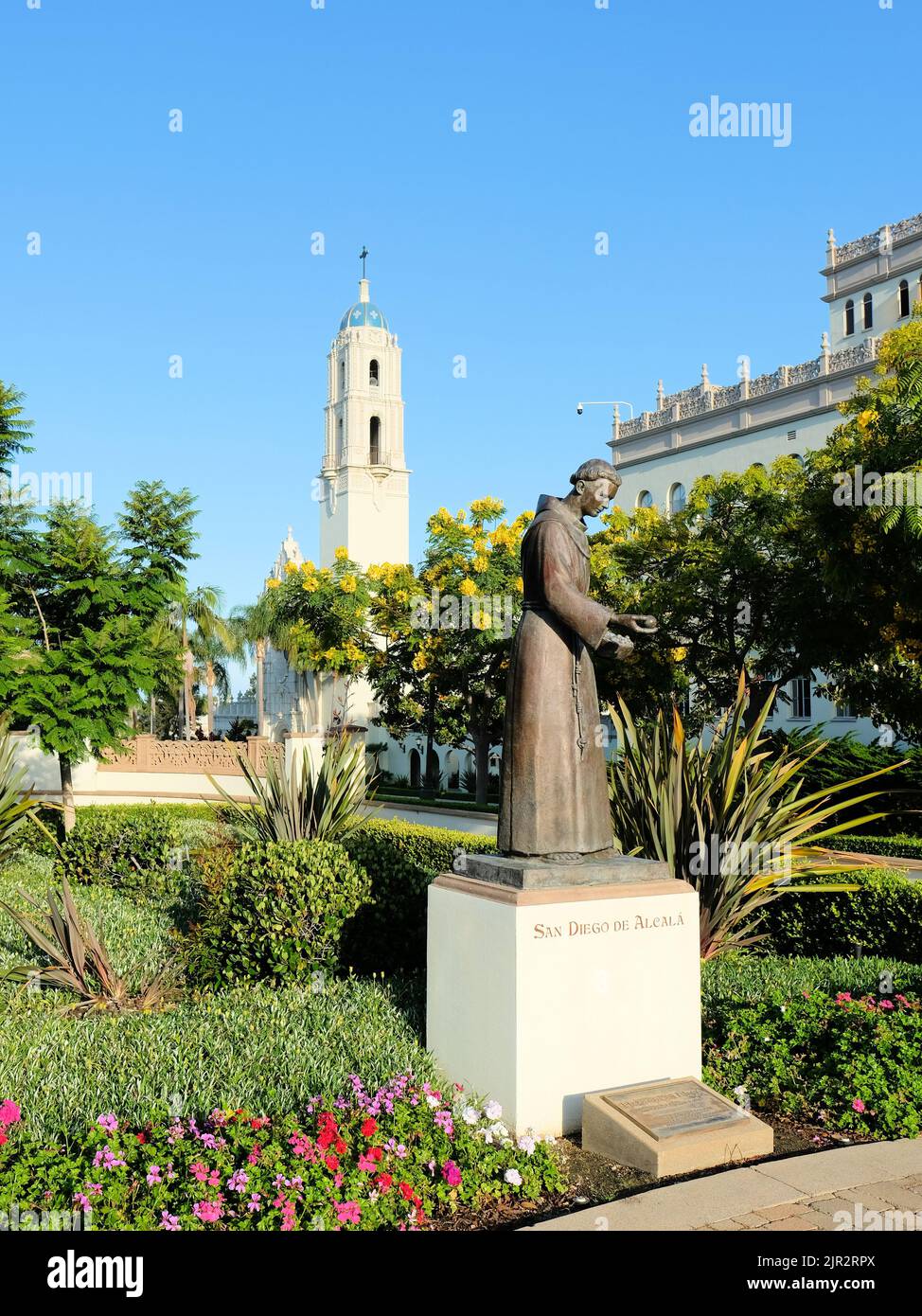 Statue de bronze de San Diego de Alcala sur le campus de l'Université de San Diego, à San Diego, Californie; tour de la paroisse d'Immaculata en arrière-plan. Banque D'Images