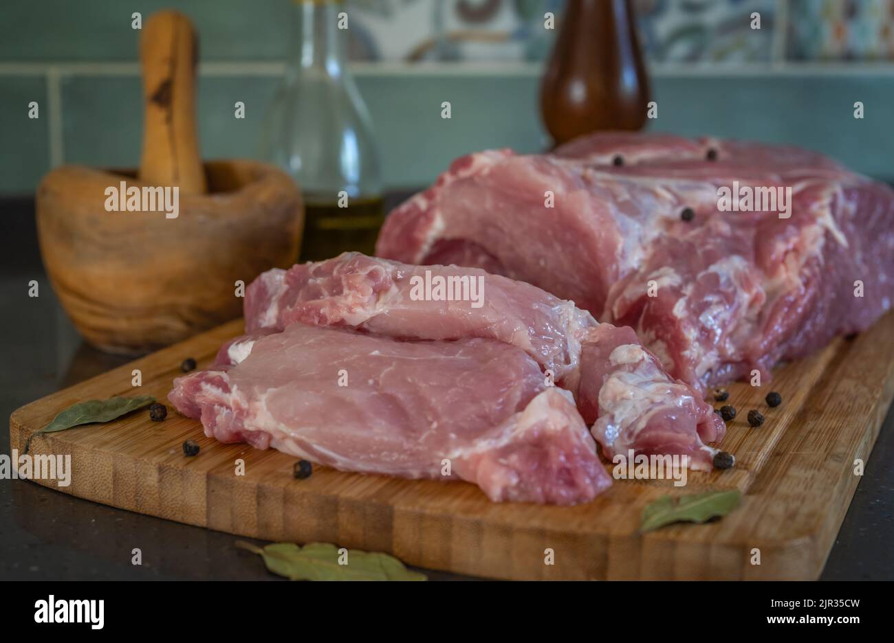 La chair de porc fraîche avec des portions crantées pour la friture repose sur une planche à découper Banque D'Images