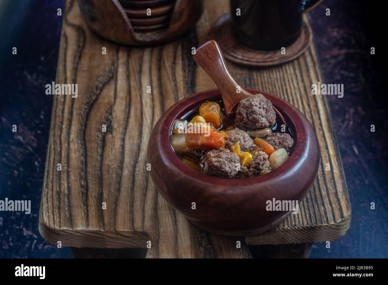 Soupe de boulettes de viande de bison dans un bol en bois sur une planche à découper en bois. Banque D'Images
