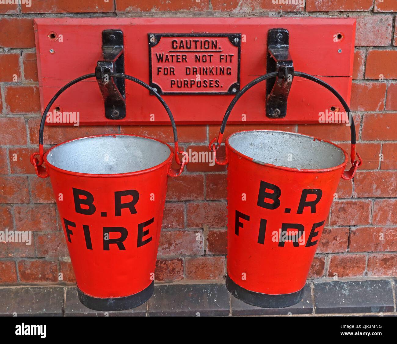 Seaux de feu à rail britannique. Panneau d'avertissement, attention, eau non potable, en fer, peint en rouge Banque D'Images