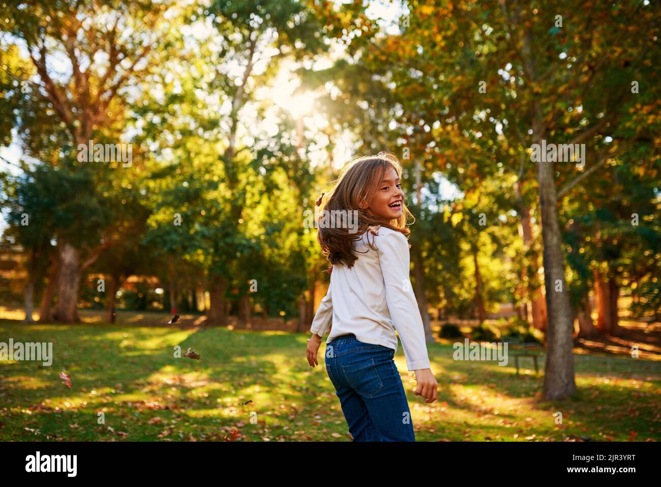Les enfants rendent chaque moment spectaculaire. Une petite fille heureuse jouant à l'automne quitte l'extérieur. Banque D'Images