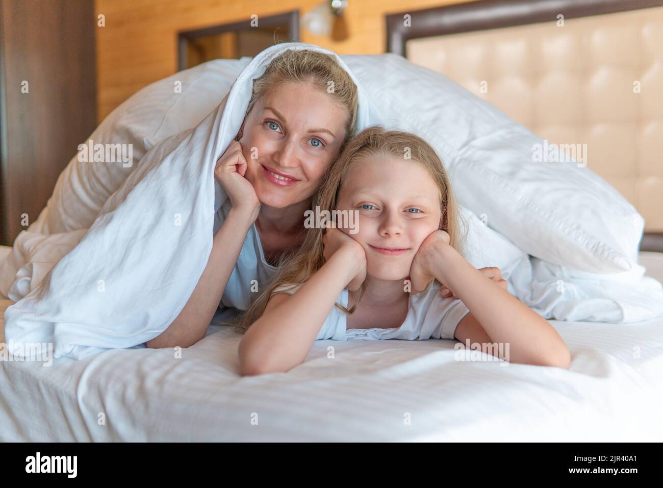 Couverture heureux sur la fille famille femme lit tête téléphone yeux, pour chambre à coucher pour l'oreiller des personnes sourire, sieste confortable. Une lumière saine, Banque D'Images