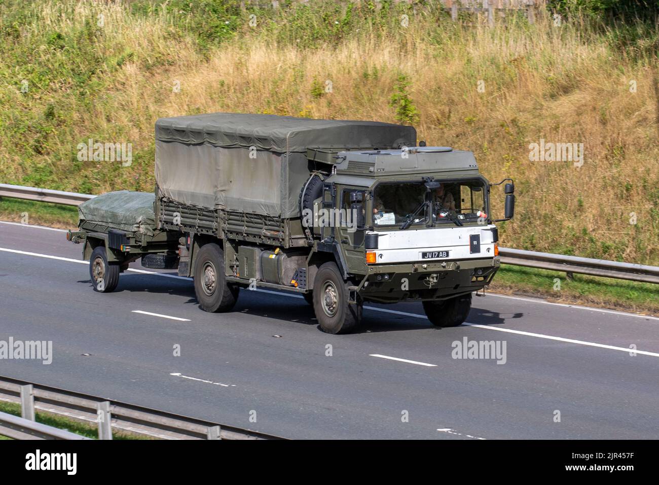 Camion de service général vert de l'armée britannique, homme recouvert de toile HX60 18,330 4x4 véhicule militaire tractant une remorque ; voyageant sur l'autoroute M6 Royaume-Uni Banque D'Images