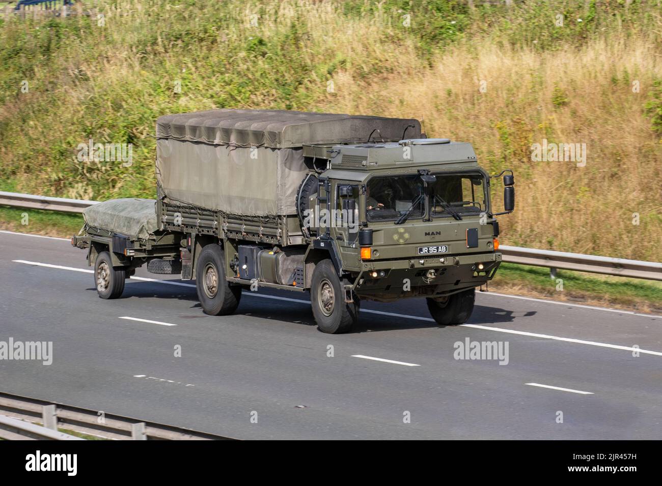 Camion de service général vert de l'armée britannique, homme recouvert de toile HX60 18,330 4x4 véhicule militaire tractant une remorque ; voyageant sur l'autoroute M6 Royaume-Uni Banque D'Images