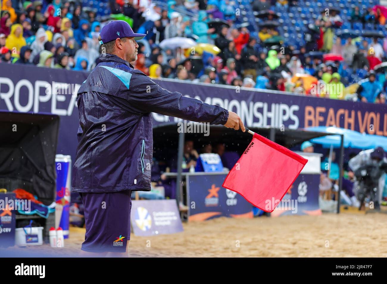 Munich, Allemagne. 20th août 2022. Volley-ball/Plage: Européen Championship1700: Doubles, femmes Un arbitre tient le drapeau dans le champ sous la pluie pour indiquer le point aux Championnats européens de Beach volley. Credit: Jean-Marc Wiesner/dpa/Alay Live News Banque D'Images