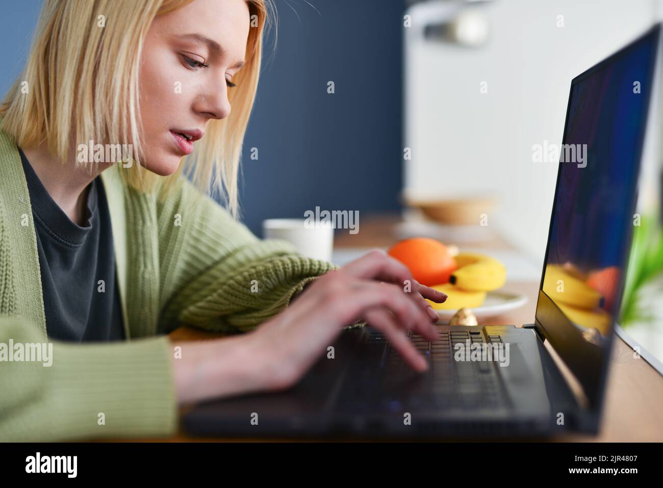 Femme à la maison avec un ordinateur portable. Banque D'Images