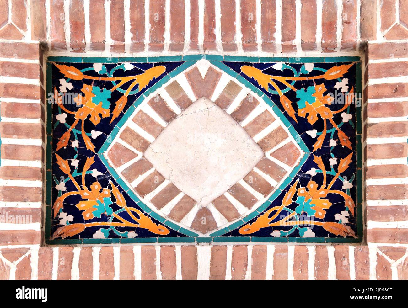Détail de vieux mur de mosaïque avec motif floral géorgien traditionnel de couleurs jaune et bleu dans un cadre de brique. Modèle de maquette. Copier l'espace pour le texte Banque D'Images