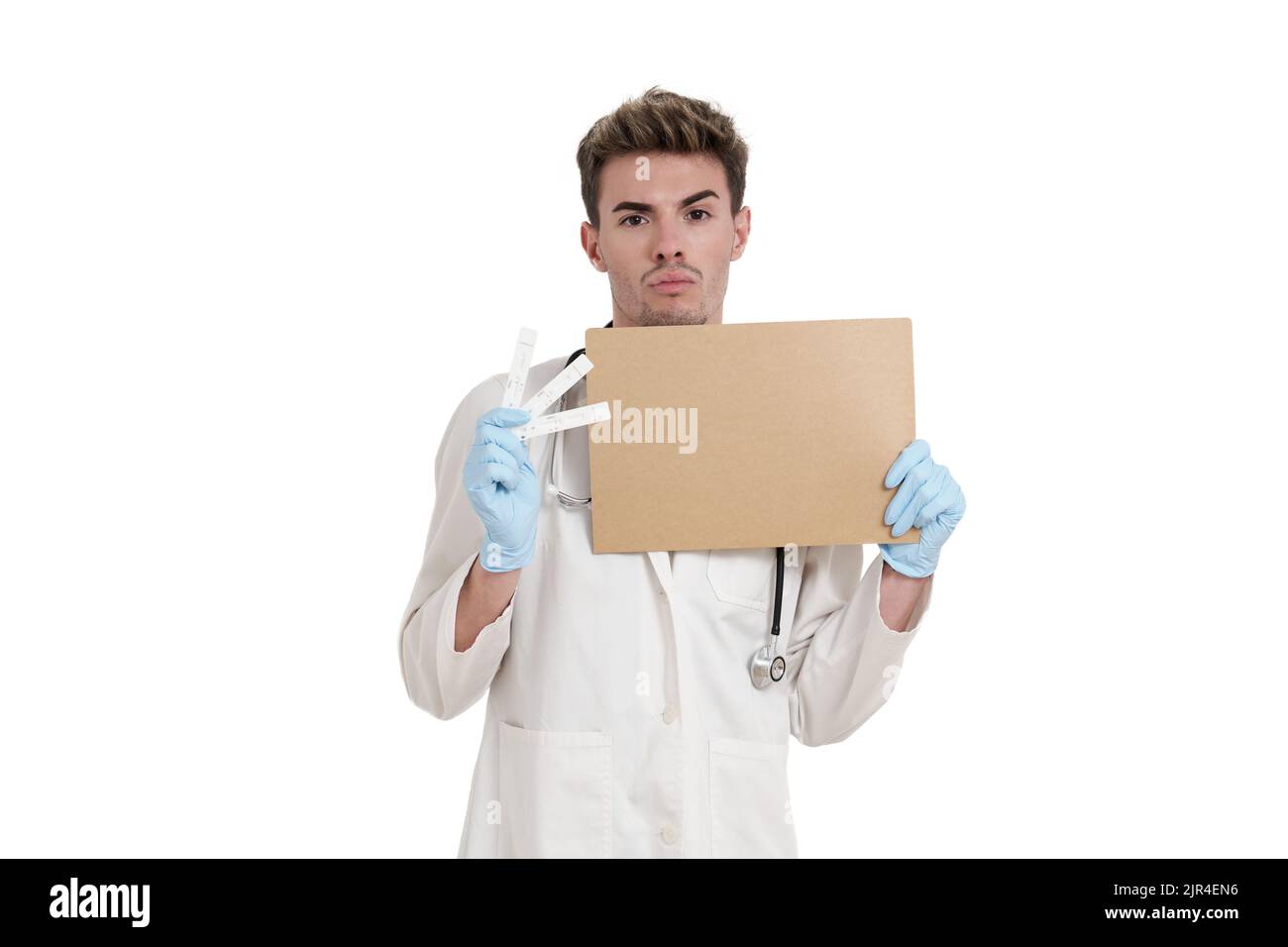 Un jeune médecin tient une carte et un test négatif de l'antigène covid-19, isolé. Banque D'Images