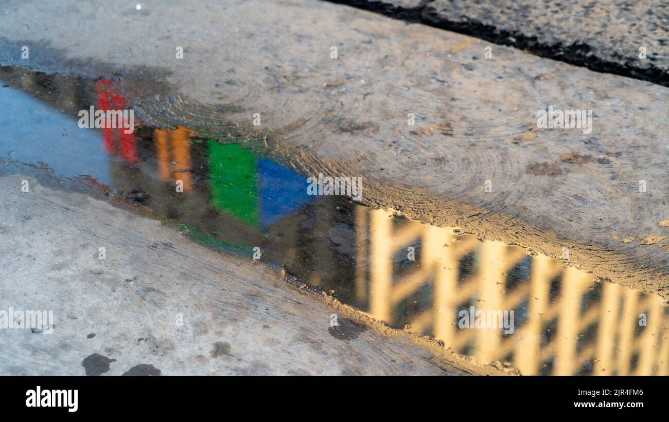Reflet de bâtiments colorés dans une flaque de pluie Banque D'Images
