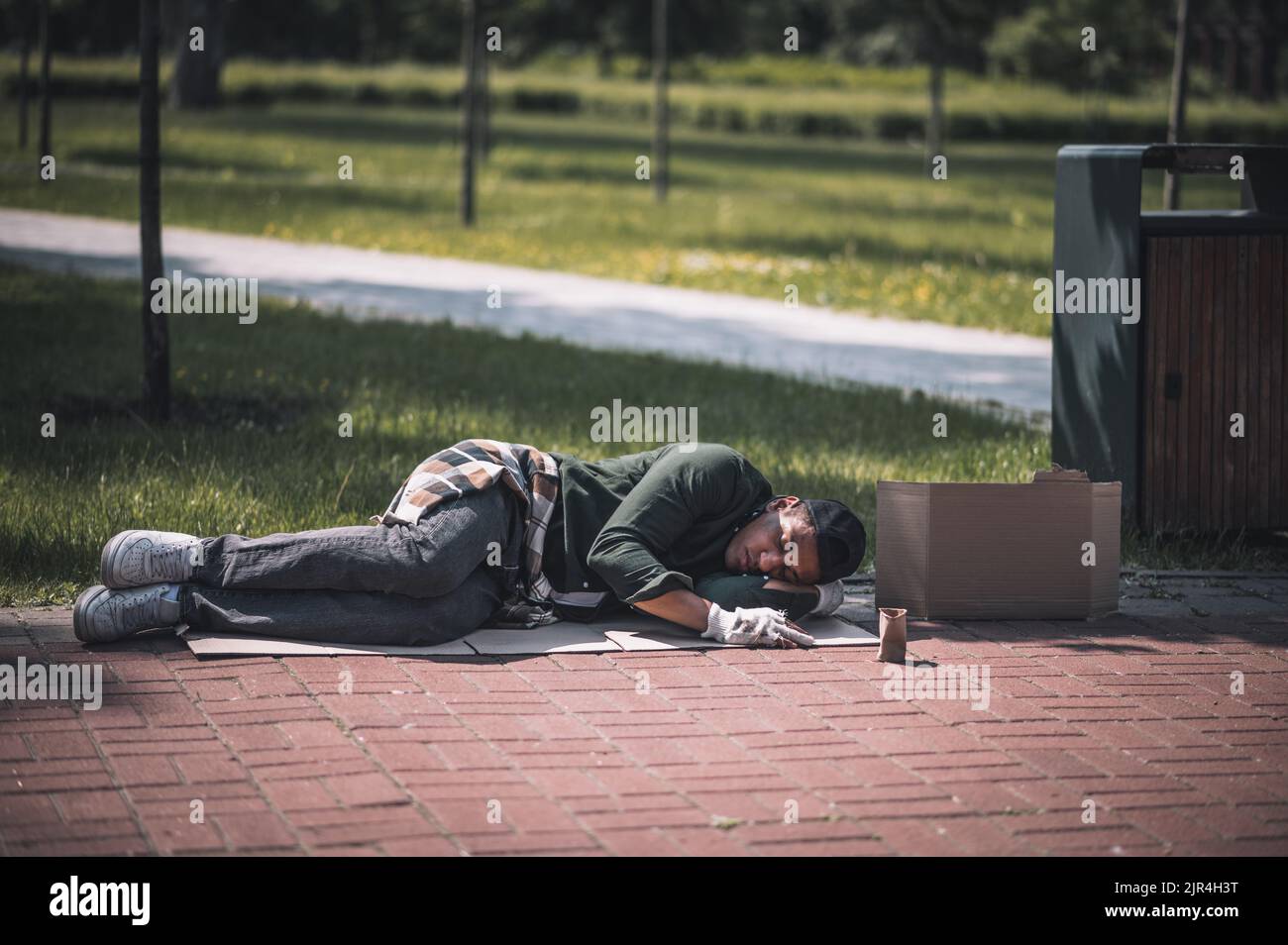 Homme à la peau sombre couché sur le sol dans le parc Banque D'Images