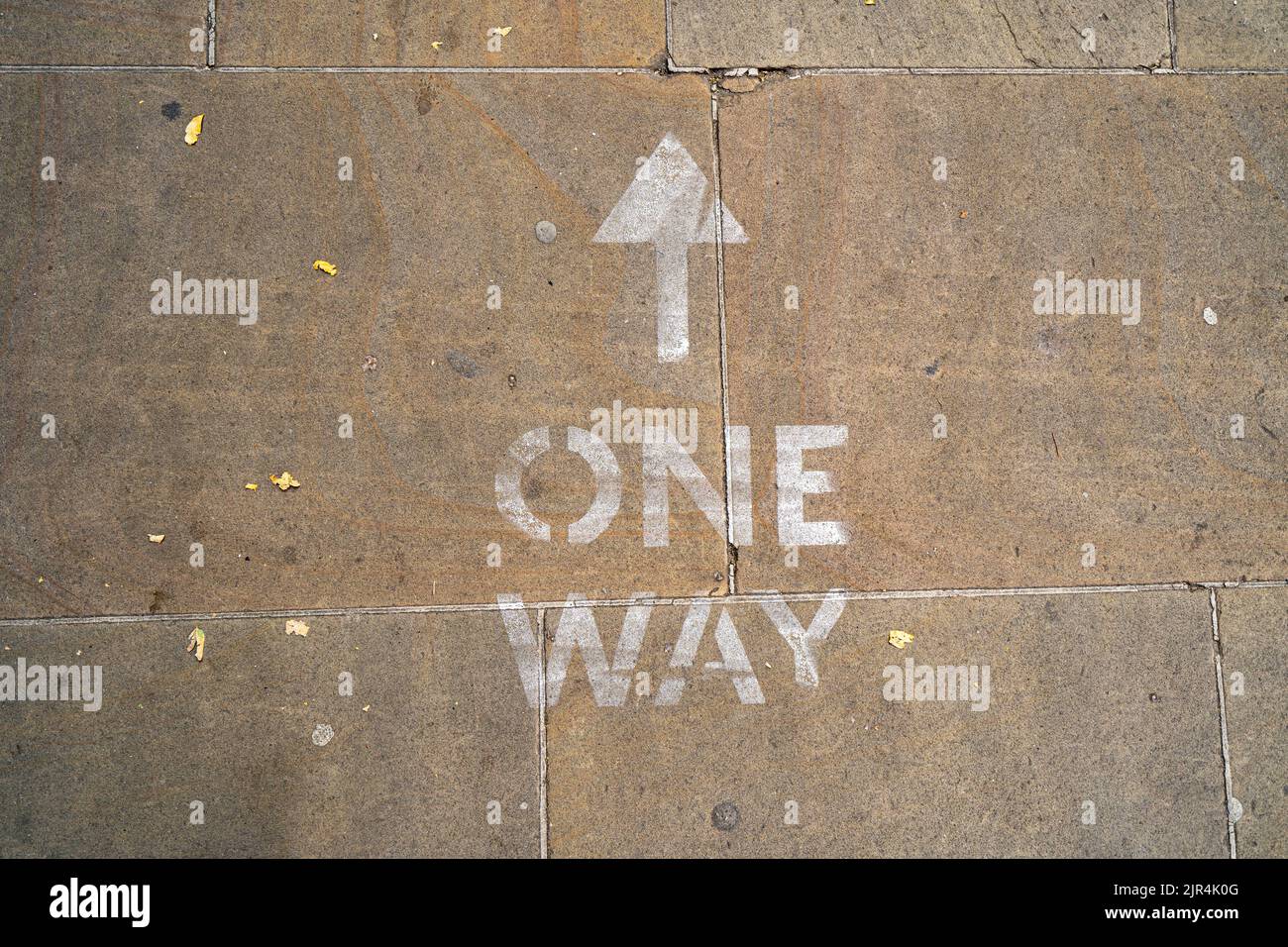 Sens unique direction flèche marquée sur le trottoir de la ville Banque D'Images