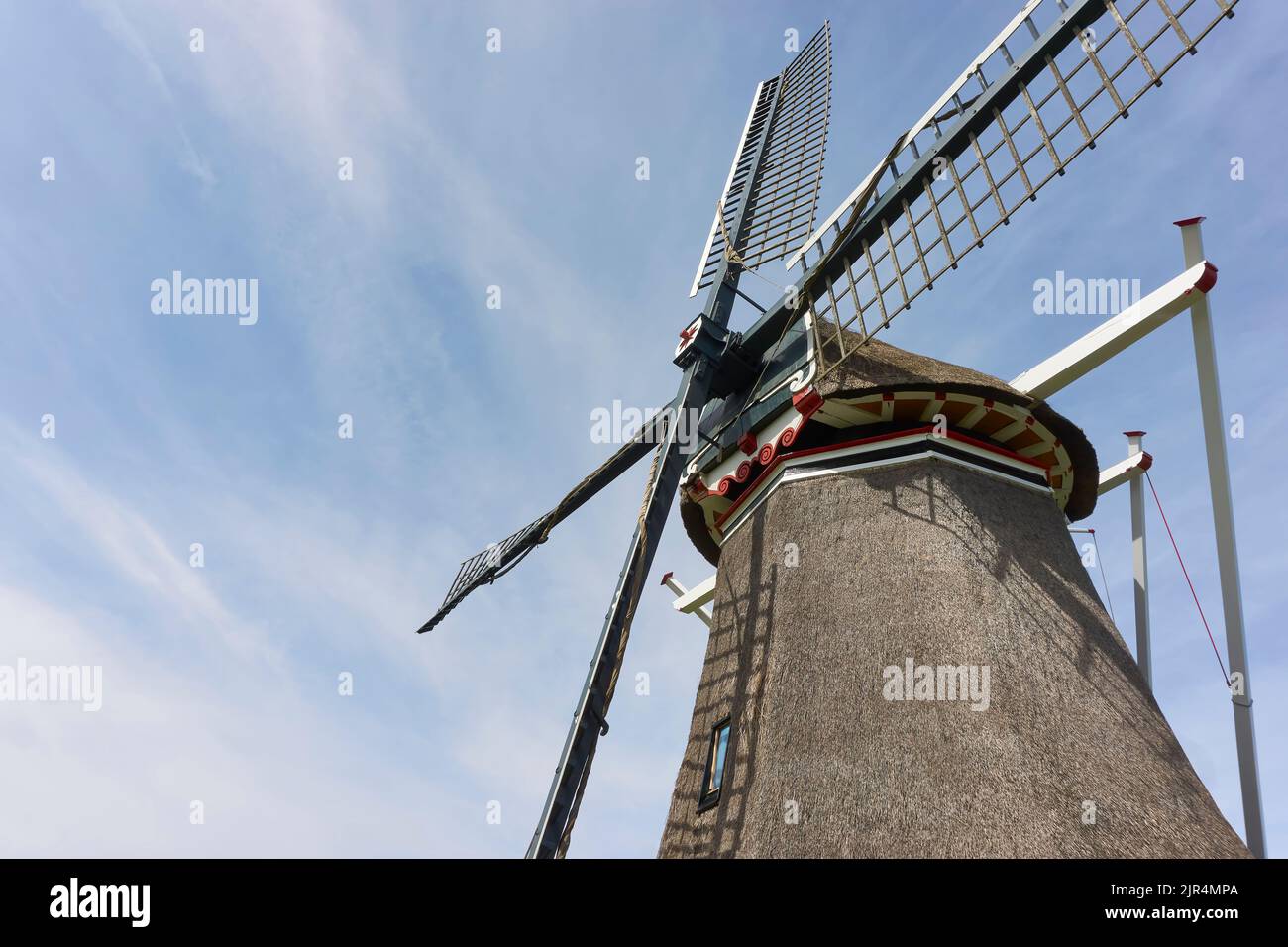 Gros plan sur les quatre ailes d'un windmil hollandais traditionnel à chaume, contre un ciel bleu avec des nuages. Image avec espace de copie. Banque D'Images