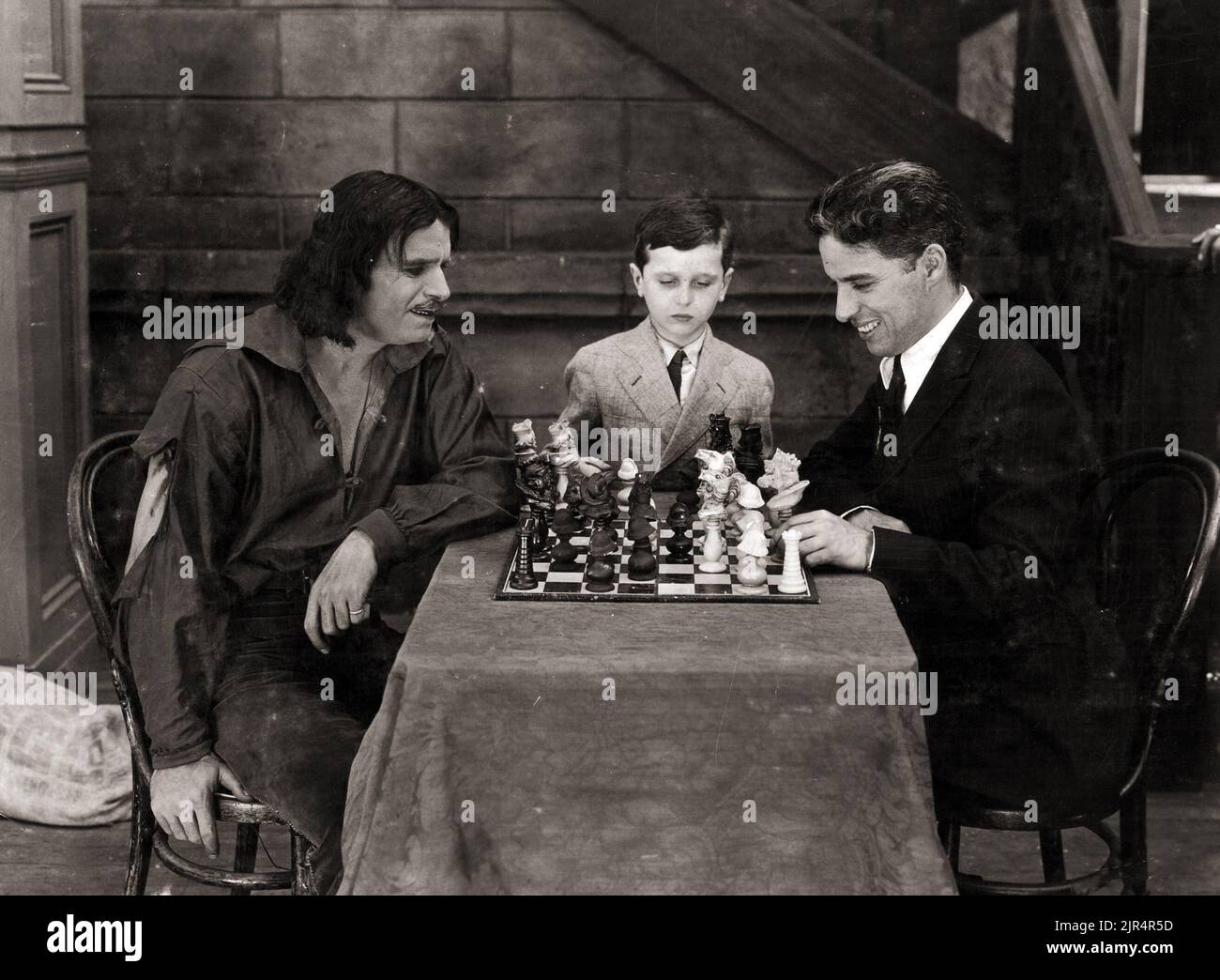 Douglas Fairbanks joue des échecs avec Charlie Chaplin, Samuel Reshevsky regarde le jeu, sur le plateau du film américain silencieux de Fairbanks les trois mousquetaires. 1921. Banque D'Images