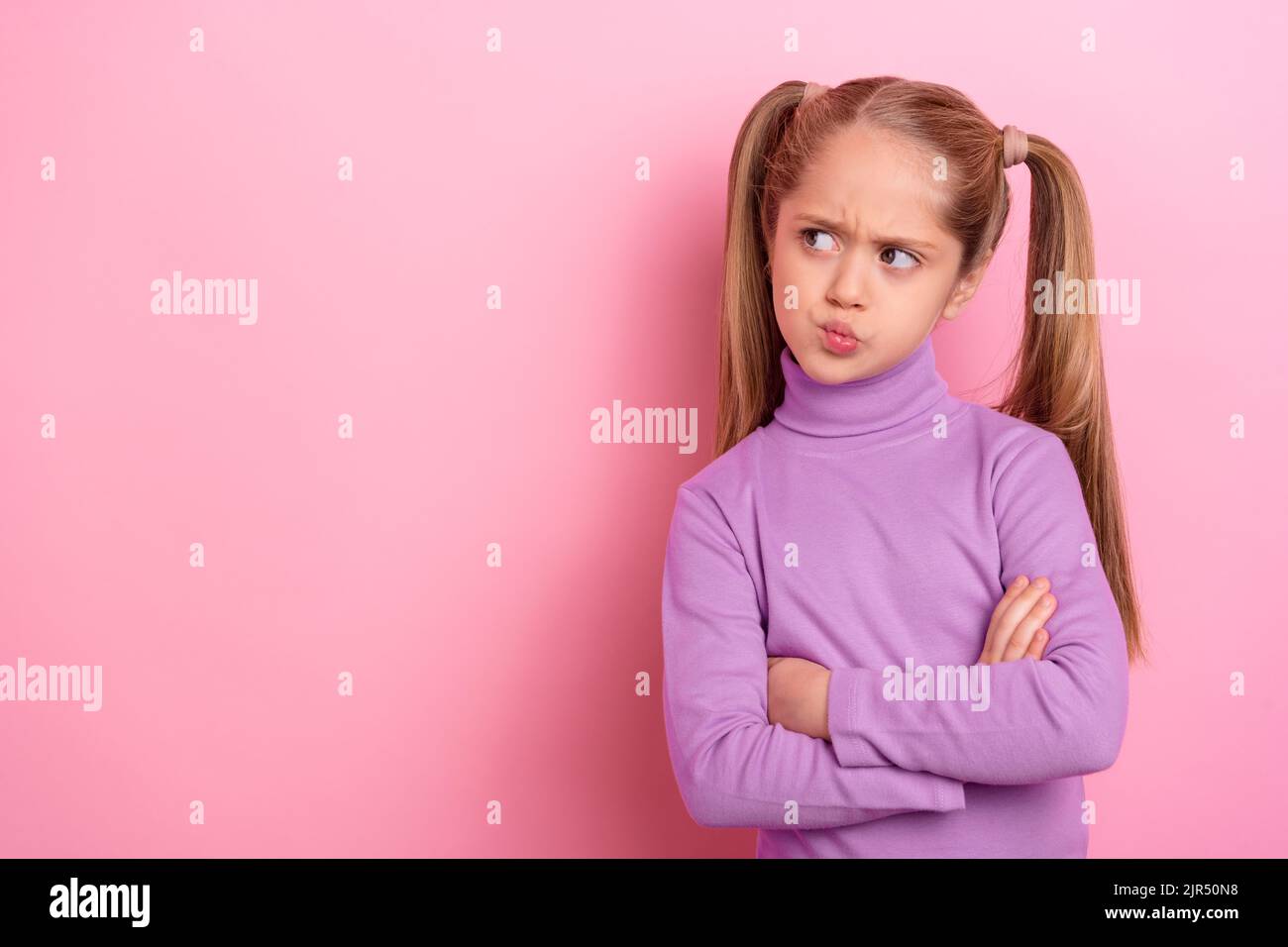 Photo de jeune charmante petite fille pensive look vide espace brainstorming isolé sur fond de couleur rose Banque D'Images