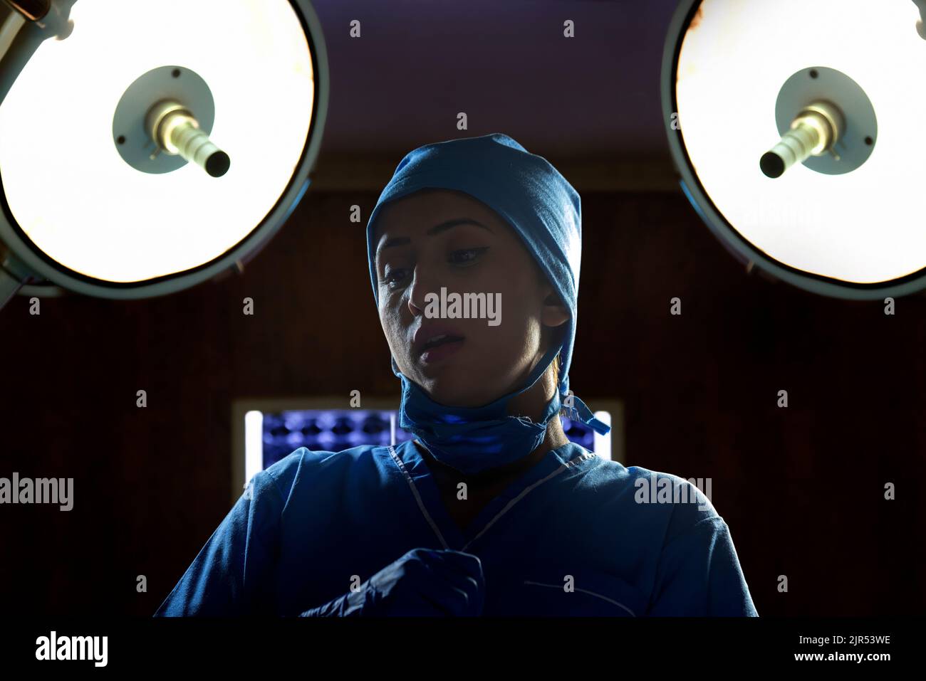 Portrait d'une infirmière féminine avec masque facial dans la salle d'opération de l'hôpital Banque D'Images Portrait d'une infirmière féminine avec masque facial dans la salle d'opération de l'hôpital Banque D'Images