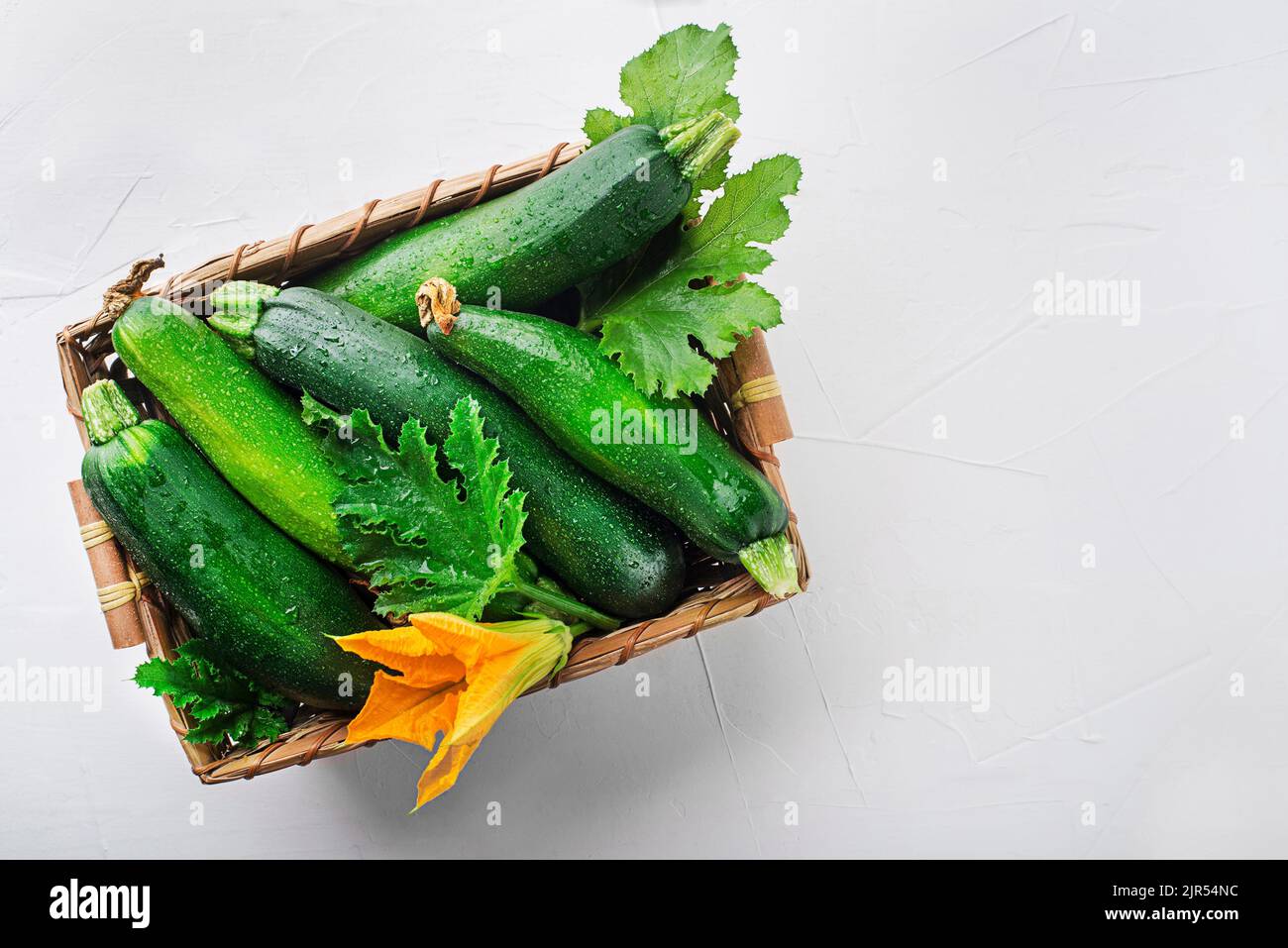 Panier de légumes frais avec courgettes fraîches sur fond blanc Banque D'Images