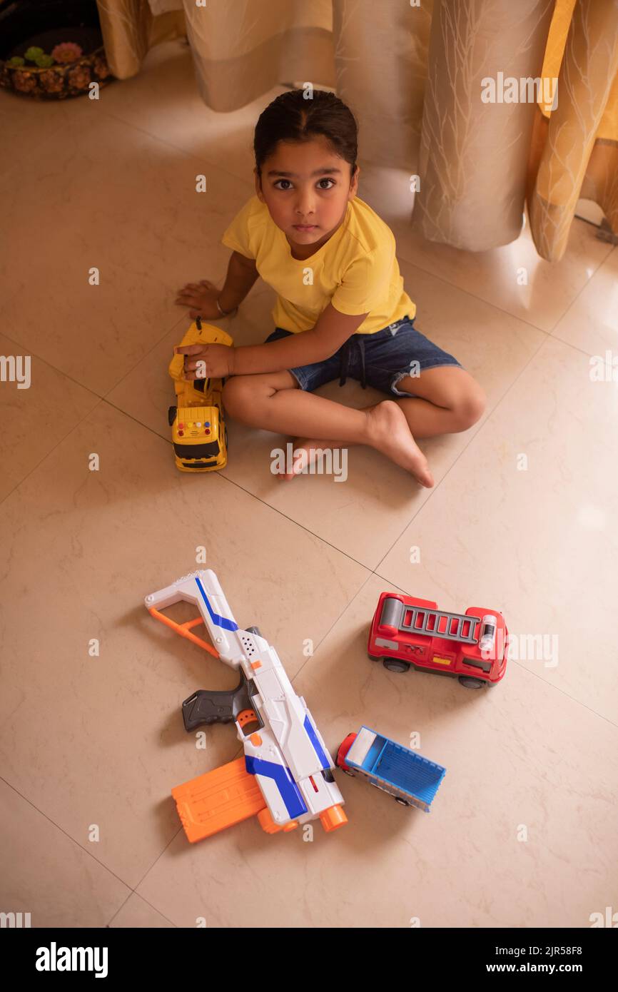 Vue en angle du dessus de la petite fille jouant avec des jouets à la maison Banque D'Images