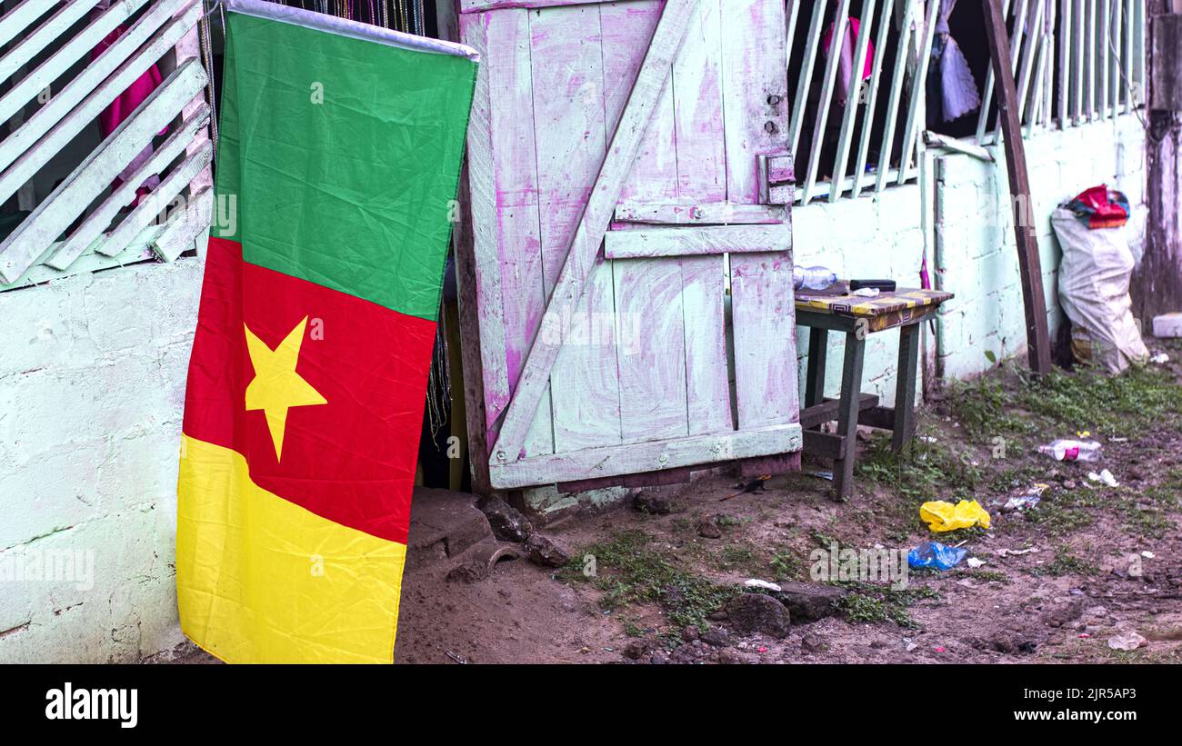 Un drapeau camerounais vole devant un restaurant de fortune camerounais dans un quartier populaire de Libreville pendant le match Cameroun-Ethiopie pour la coupe d'Afrique des Nations 2021 au Cameroun sur 14 janvier 2022. Banque D'Images