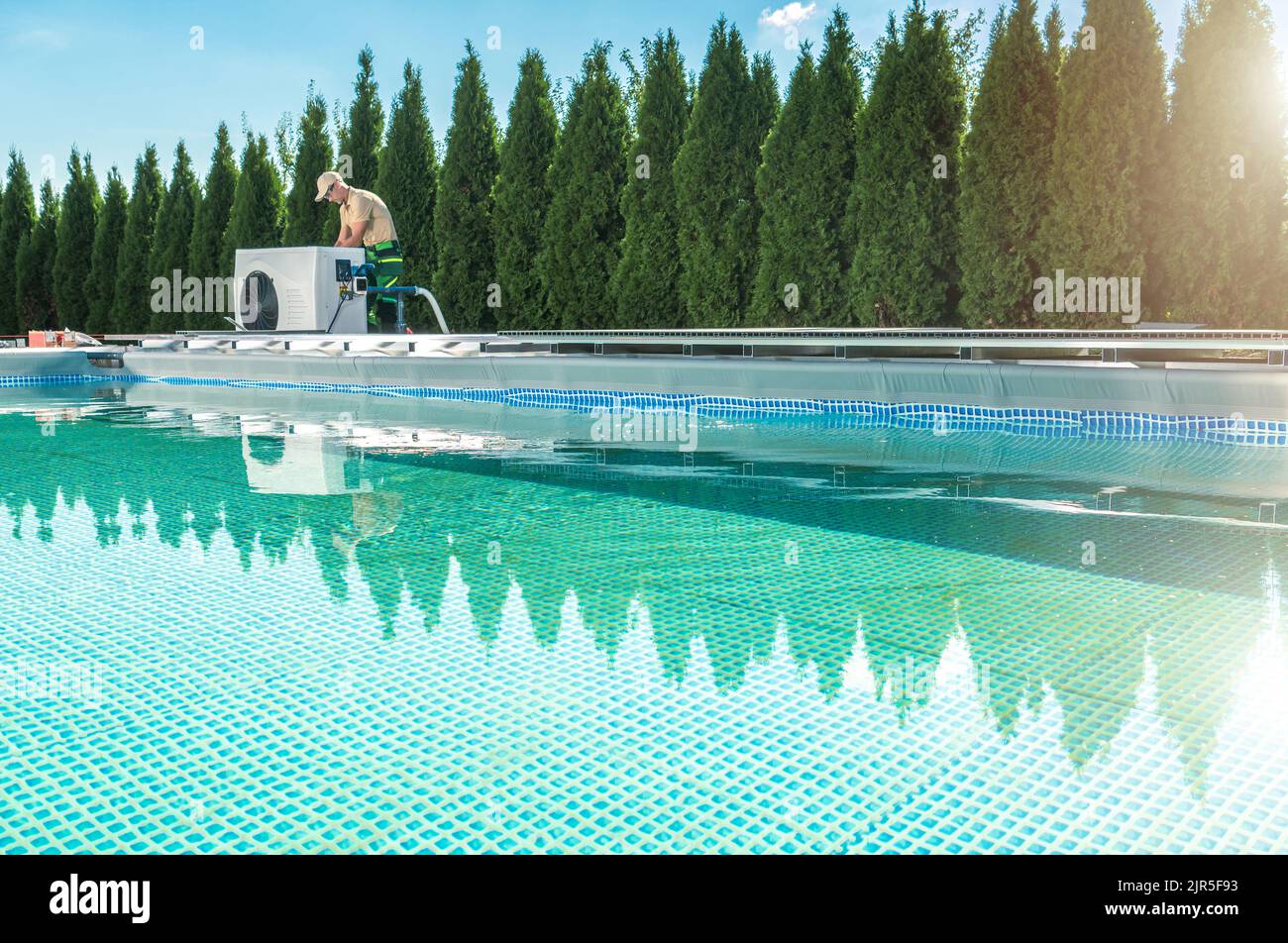 Piscine extérieure chauffage par pompe à chaleur. Le technicien HVAC teste un nouveau périphérique à côté du pool. Banque D'Images