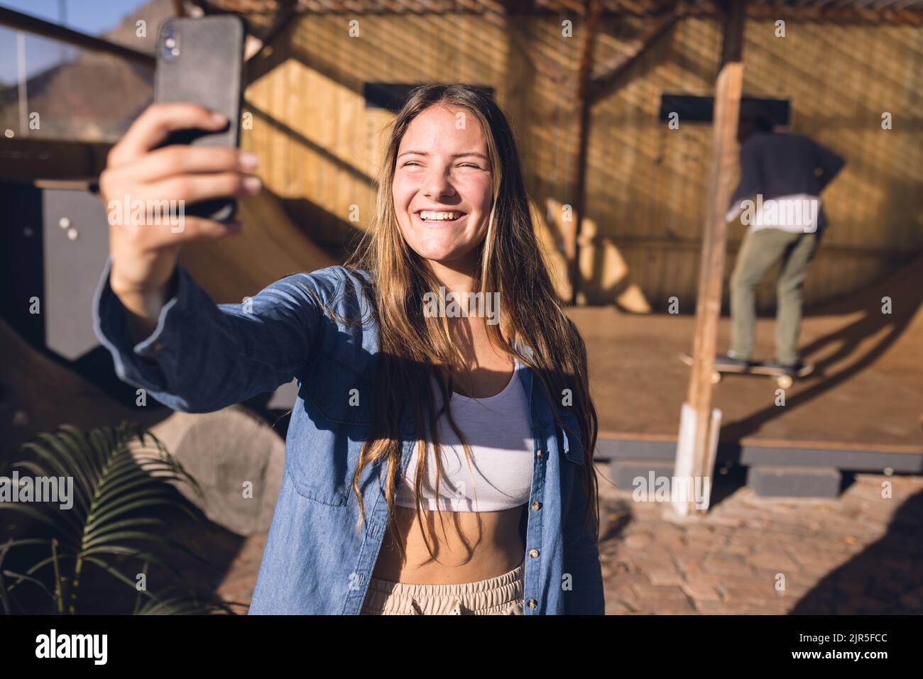 Image de la bonne femme caucasienne prenant le selfie dans le parc de skate Banque D'Images
