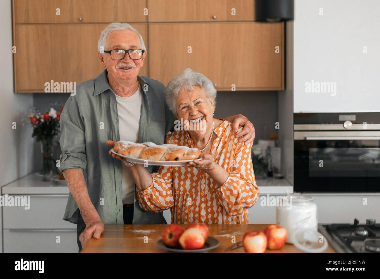 Joyeux couple senior avec du pain tressé sucré fait maison avec des raisins secs. Banque D'Images