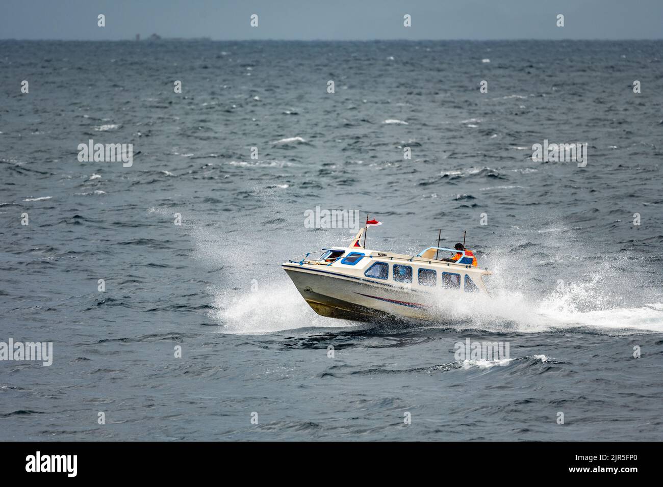 Bateau à grande vitesse sur une mer agitée. Île de Ternate, Nord de Maluku, Indonésie. Banque D'Images