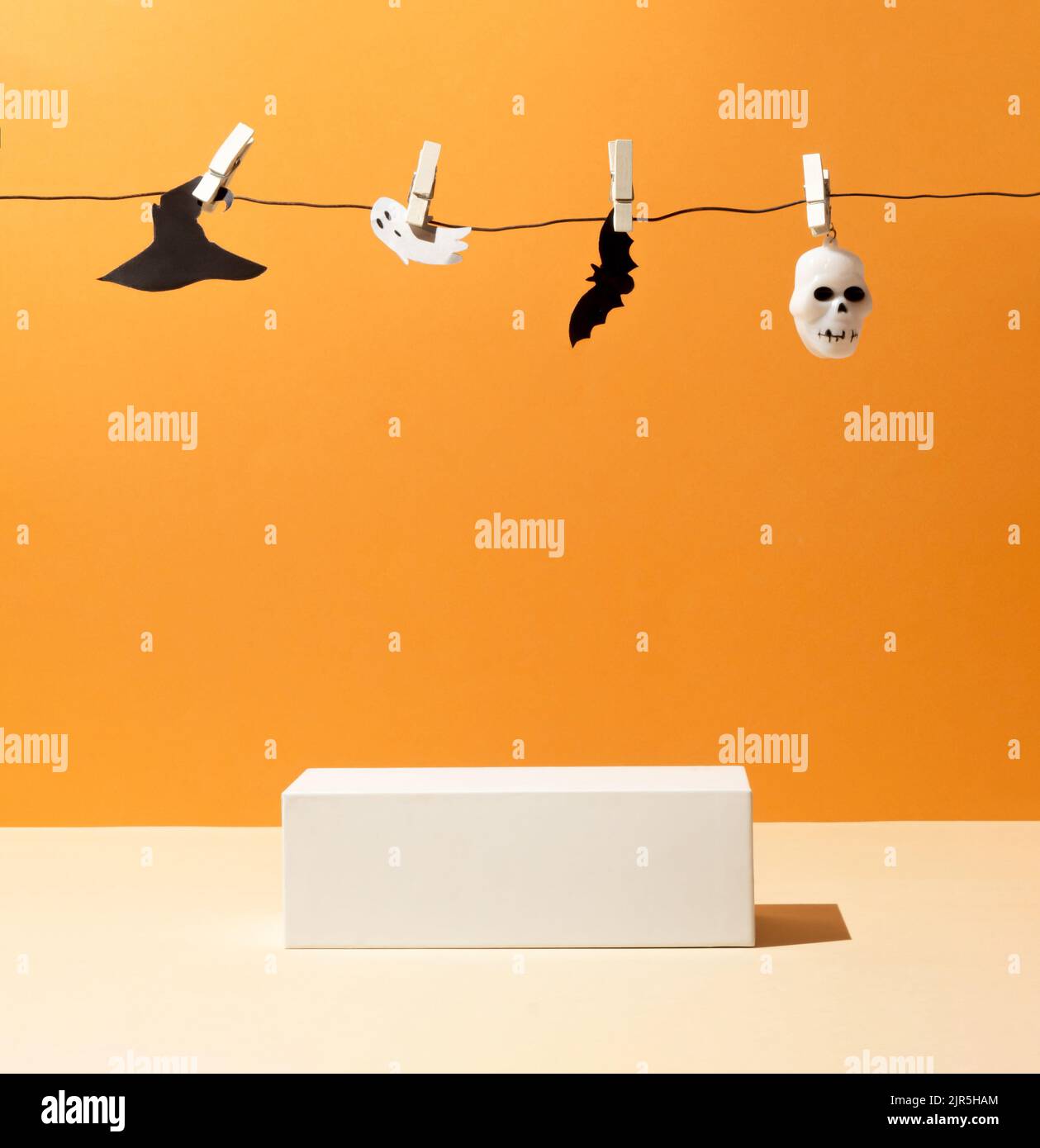 Présentation du produit sur fond orange avec podium, silhouette de chauve-souris, crâne, fantôme et chapeau de sorcière. Adapté à l'affichage des produits et au concept commercial. Tre Banque D'Images