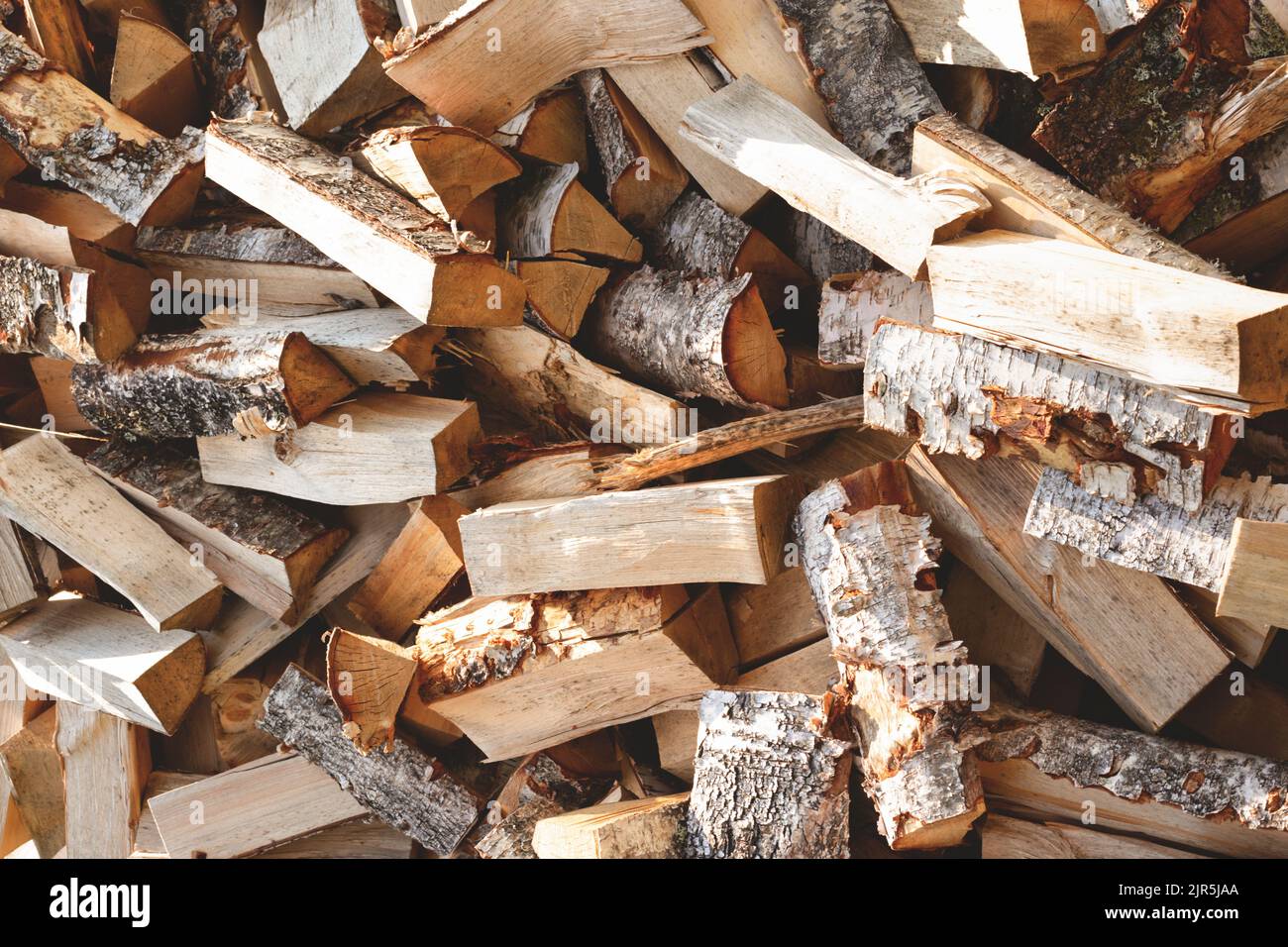 Bois de chauffage de bouleau haché avec une hache. Pile de bois désordonnée, gros plan. Banque D'Images