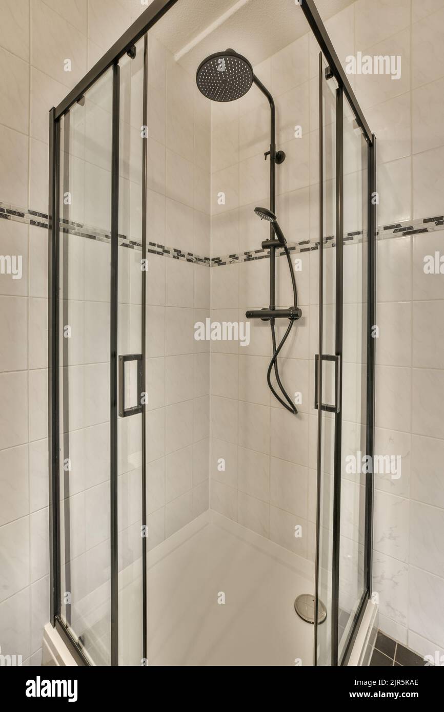 Meuble-lavabo et meuble miroir dans la salle de bains carrelée de blanc avec toilettes accrochées au mur Banque D'Images