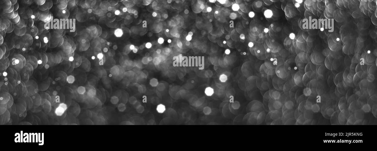 Fond de bokeh scintillant gris noir, texture décorative abstraite de noël. Lumières de Noël. Affiche supérieure en forme d'étoiles brillantes et enneigées Banque D'Images
