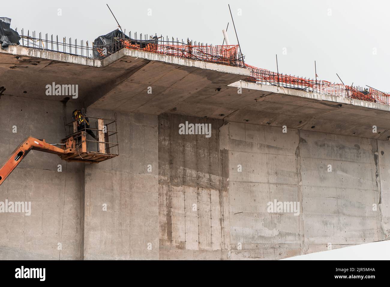 Travailleur latin effectuant des réparations sur un pont monté sur une grue au Nicaragua, en amérique centrale Banque D'Images