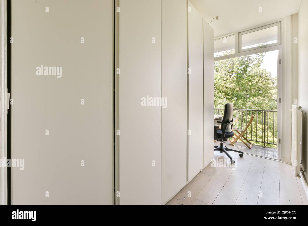 Intérieur moderne plat de style minimaliste avec couloir vide étroit éclairé par des lampes Banque D'Images
