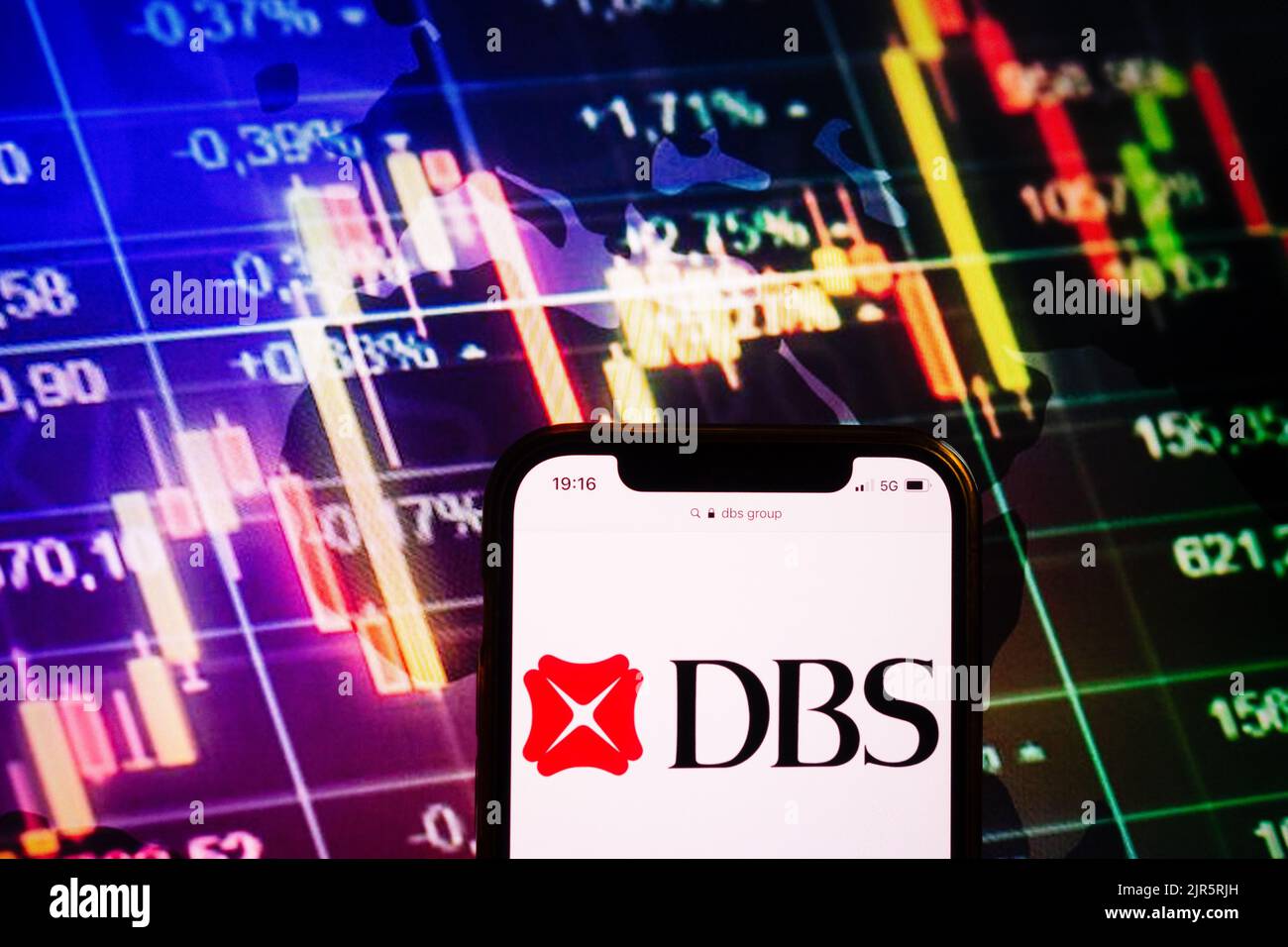 KONSKIE, POLOGNE - 10 août 2022: Smartphone affichant le logo de la société du Groupe DBS sur fond de diagramme boursier Banque D'Images