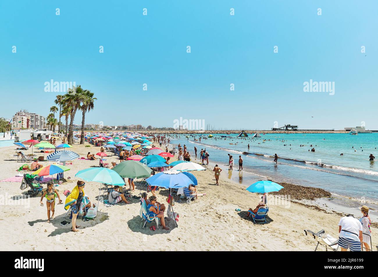 Torrevieja, Espagne - 2 août 2022: Beaucoup de gens bronzer sur la plage de Naufragos, profiter de la mer Méditerranée passer des vacances sur la côte de sable. Vacances d'été Banque D'Images