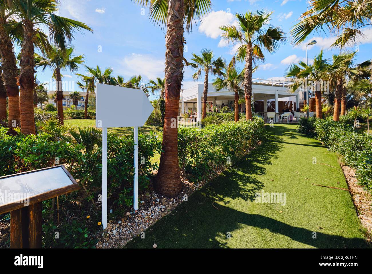 Entrée bordée de palmiers au restaurant tropical sur la plage pendant une journée ensoleillée d'été. Province d'Alicante, Costa Blanca, Espagne. Voyage, vacances, su Banque D'Images