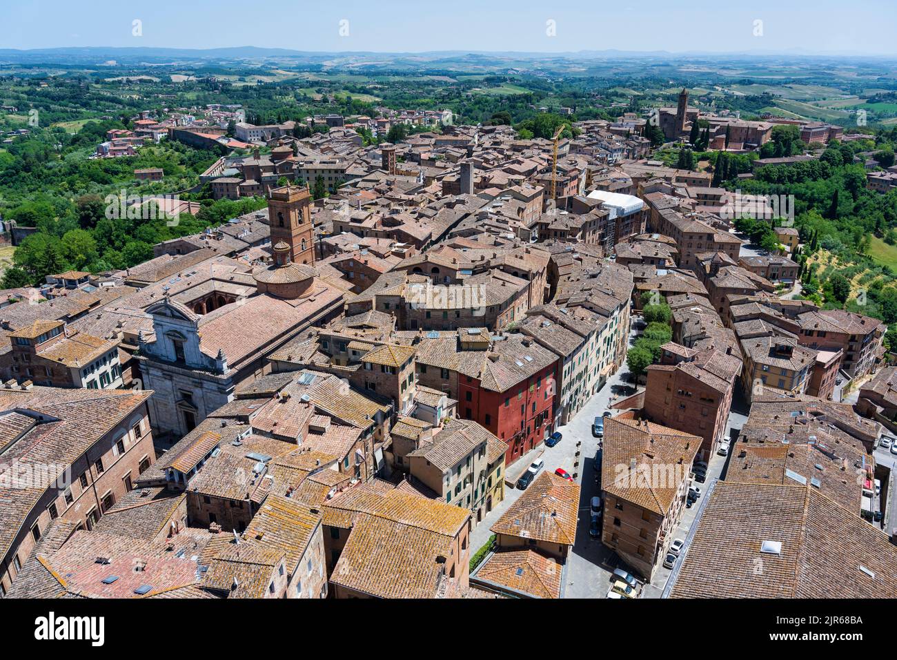 Vue depuis le haut du clocher de Torr del Mangia sur les toits carrelés rouges, avec Chiesa di San Martino à proximité, à Sienne, Toscane, Italie Banque D'Images