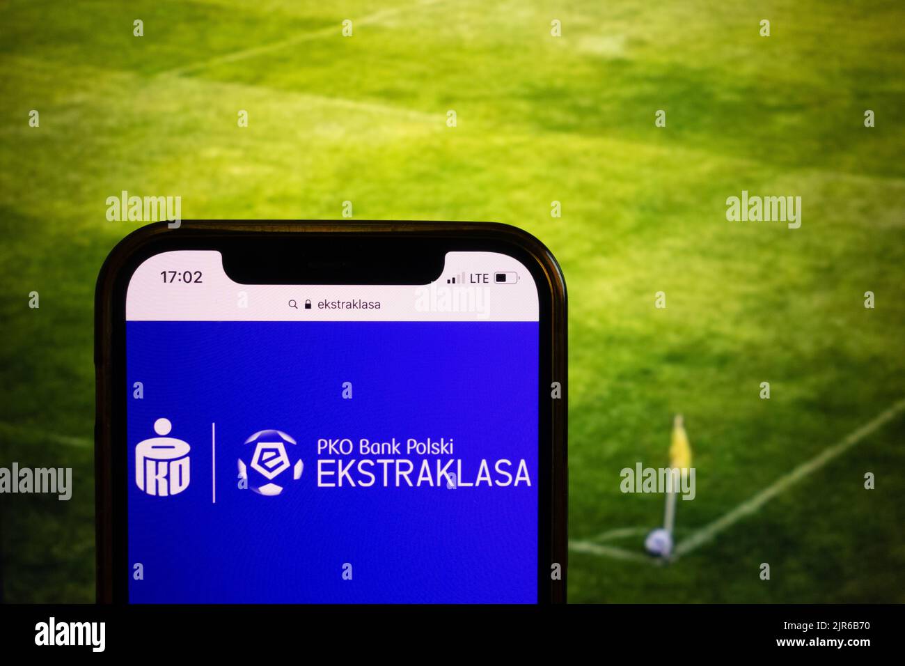 KONSKIE, POLOGNE - 21 août 2022: Smartphone affichant le logo de la ligue de football polonaise PKO Bank Polski Ekstraklasa sur fond de stade de football Banque D'Images