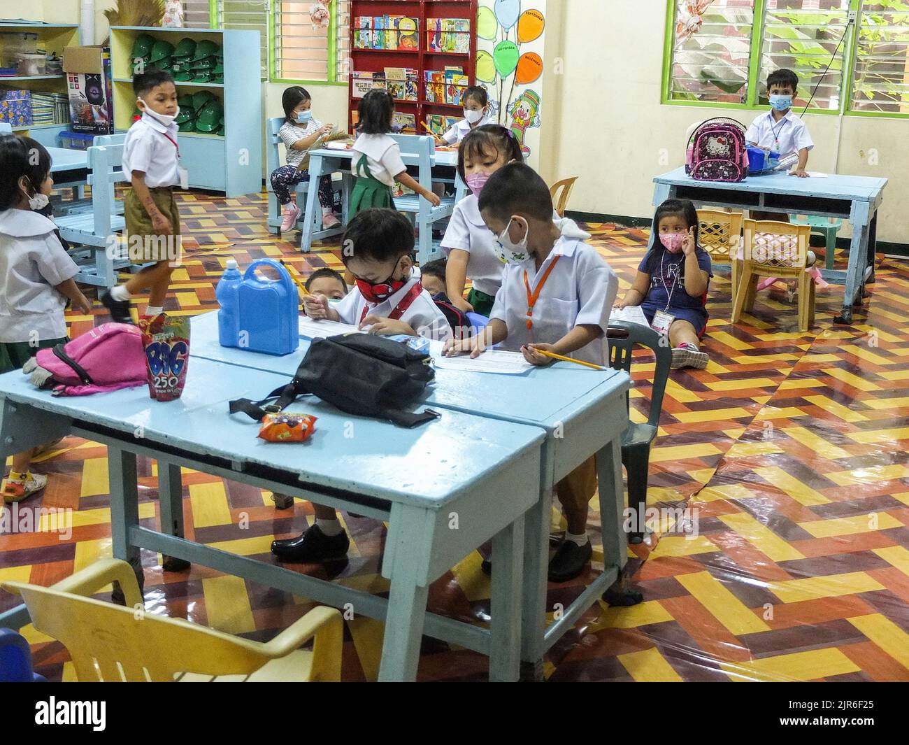 Malabo City, Philippines. 22nd août 2022. Les jeunes élèves écrivent leur nom sur un papier lors de leur première journée d'école. Après deux années d'école sans cours en face à face, les couloirs et les salles de classe vides seront remplis une fois de plus d'élèves, puisque le ministère de l'éducation (Depud) ouvre officiellement le début de l'année scolaire 2022-2023 le lundi 22 août. Crédit : SOPA Images Limited/Alamy Live News Banque D'Images