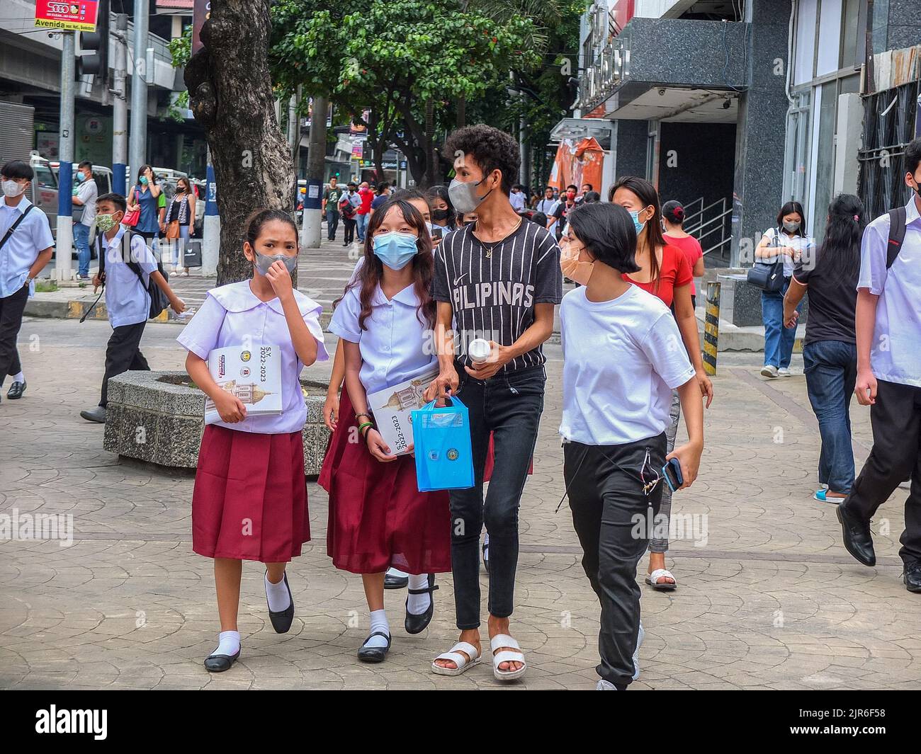 Manille, Philippines. 22nd août 2022. Les étudiants accompagnés de leur aide à la maison marchent le long de l'avenue Taft à Manille. Après deux années d'école sans cours en face à face, les couloirs et les salles de classe vides seront remplis une fois de plus d'élèves, puisque le ministère de l'éducation (Depud) ouvre officiellement le début de l'année scolaire 2022-2023 le lundi 22 août. Crédit : SOPA Images Limited/Alamy Live News Banque D'Images