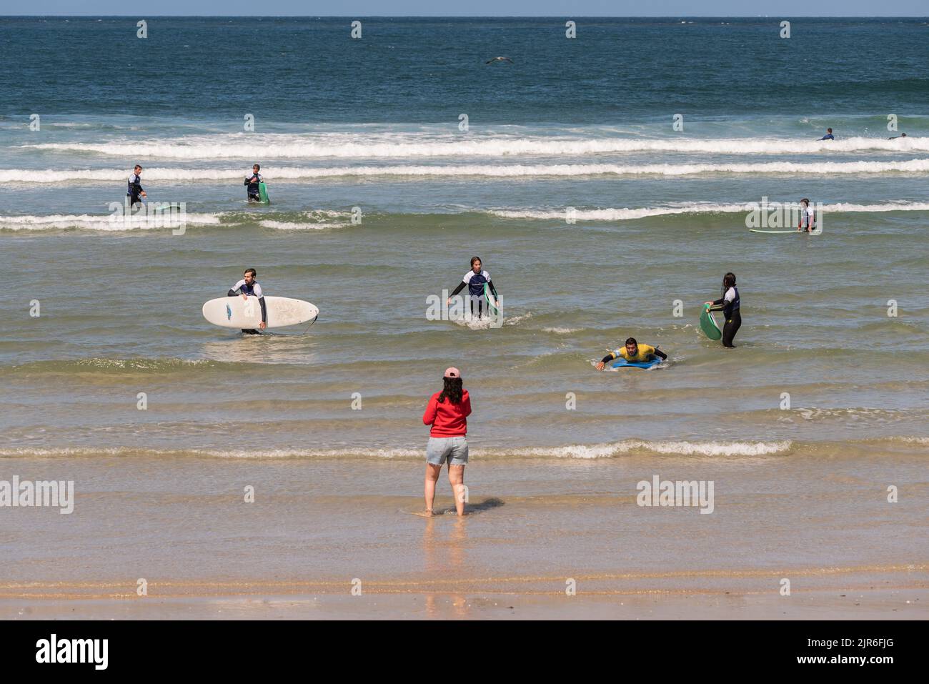 aveiro - portugal. 16 août 2022: Cours de surf à Aveiro Portugal. Un groupe d'étudiants d'âges et d'ethnies différents sort de la mer Banque D'Images