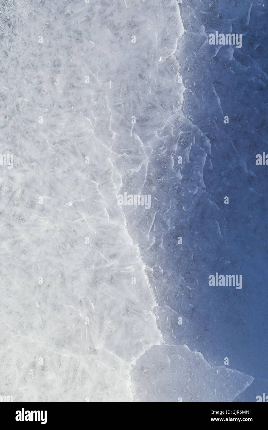 Gros plan de glace fissurée sur un lac gelé en hiver, vue d'en haut. Arrière-plan abstrait texturé plein cadre. Espace de copie, vue de dessus. Banque D'Images